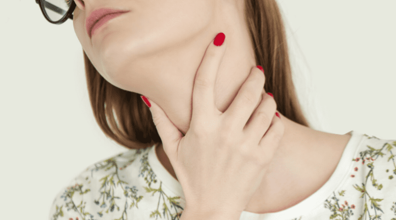 Woman with hand on her neck illustrating hashimoto's hypothyroidism