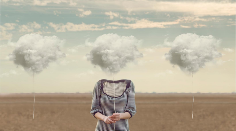 Torso of a woman holding a cloud on a string in place of her head to illustrate brain fog