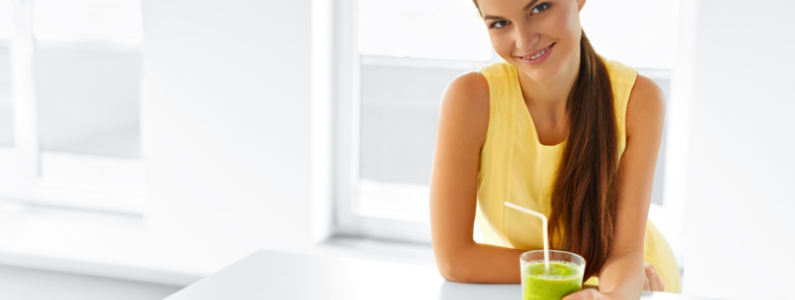 Woman holding a green smoothie.