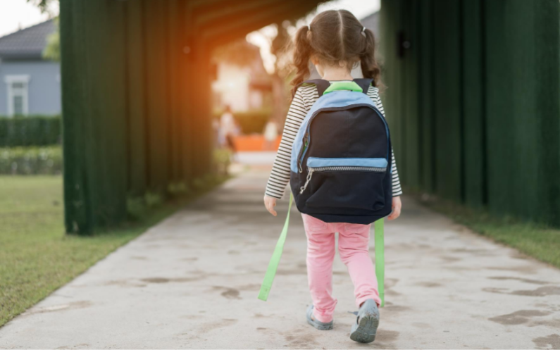 young girl walking with a backpack on