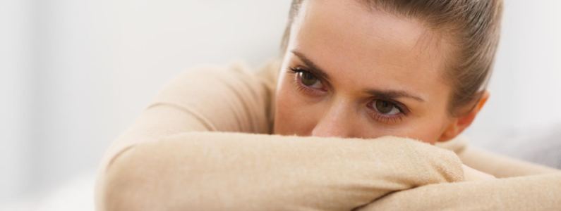 Stressed woman with her head resting on her folded arms