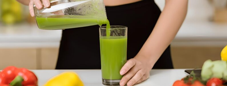 A person pouring green juice into a glass.