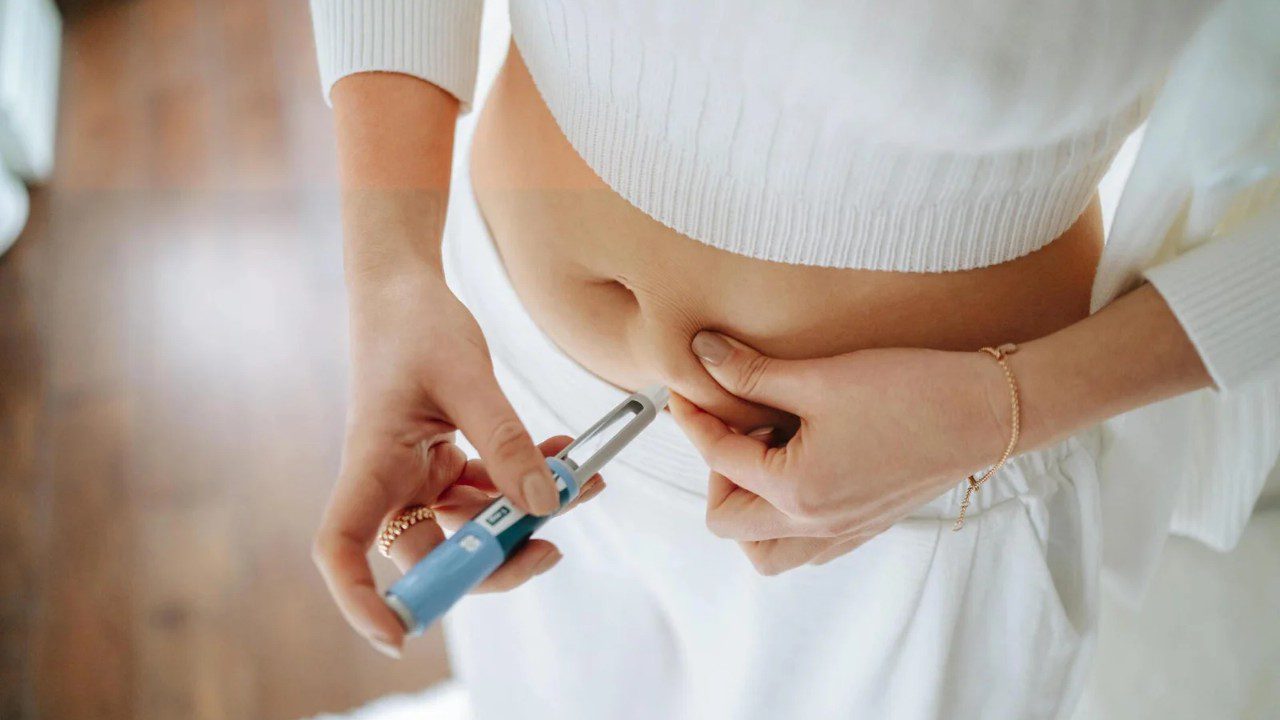 A woman is holding an electronic device in her hand.