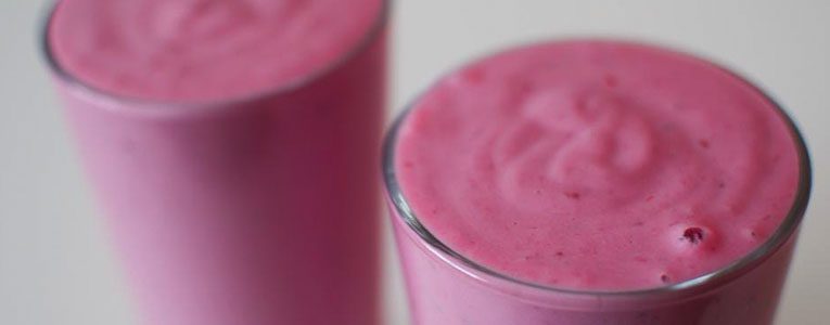 A close up of two glasses with pink liquid