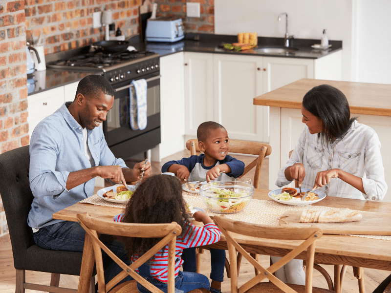 A family sitting at the table eating food.