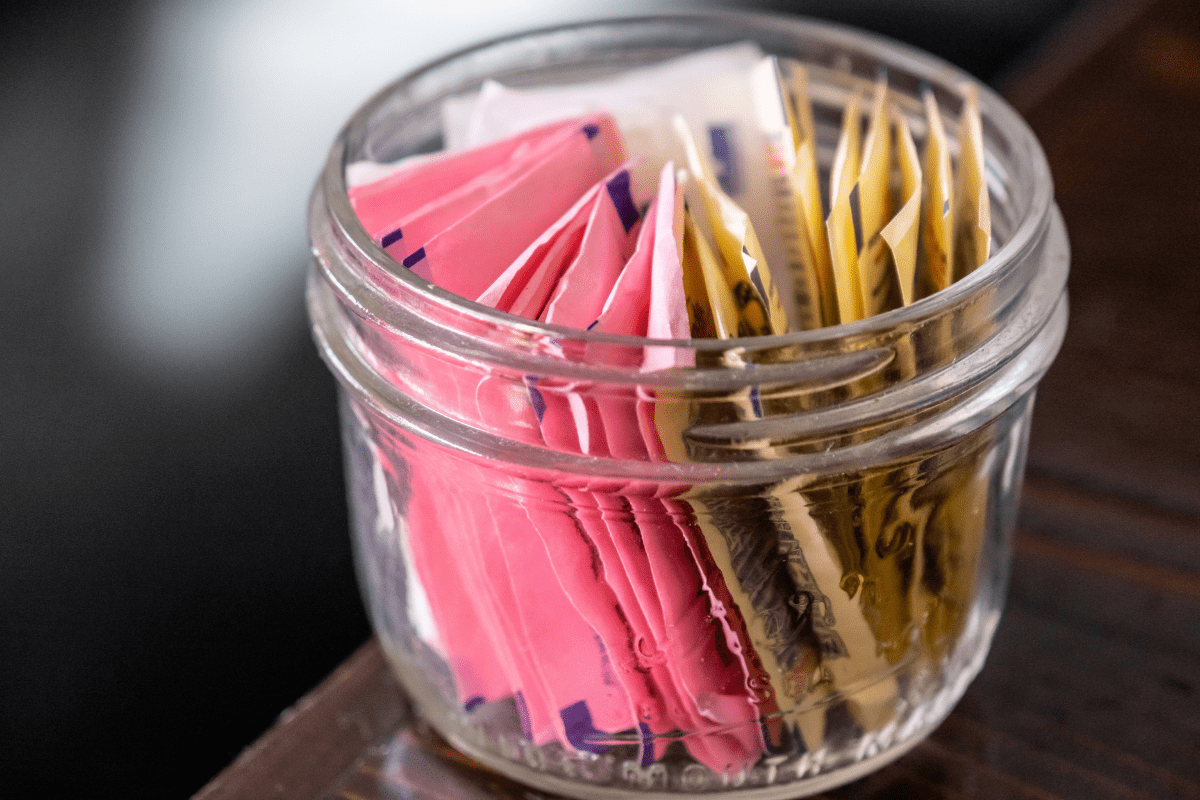 A glass jar filled with tea bags on top of a table.