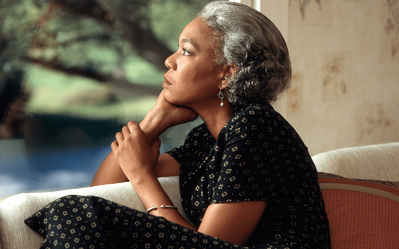 A woman sitting down with her head resting on her hand.