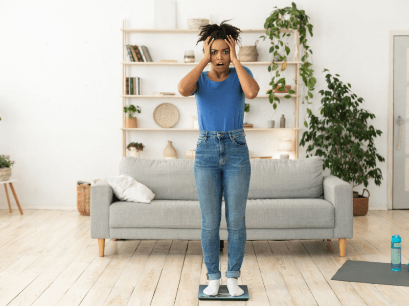 A woman standing on a scale in the living room