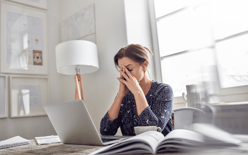 A woman sitting at a table with her laptop.